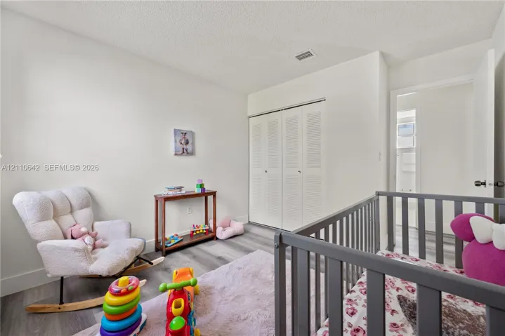 Interior room featuring wood-finish flooring and double bi-fold louvered closet doors