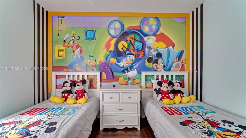 Custom wall mural with integrated yellow accent border, vertical black-and-white striped wall treatments, and wood-finish flooring