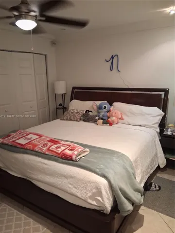 Room featuring tile flooring, ceiling fan with integrated lighting, and bi-fold closet doors