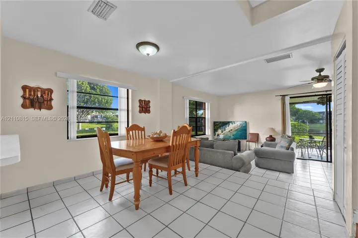 Living area featuring tile flooring, ceiling fans, recessed lighting, and multiple windows providing natural light, inclusive of a sliding glass door to exterior space