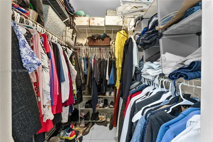 Walk-in closet featuring multi-level white wire shelving and integrated vertical storage compartments