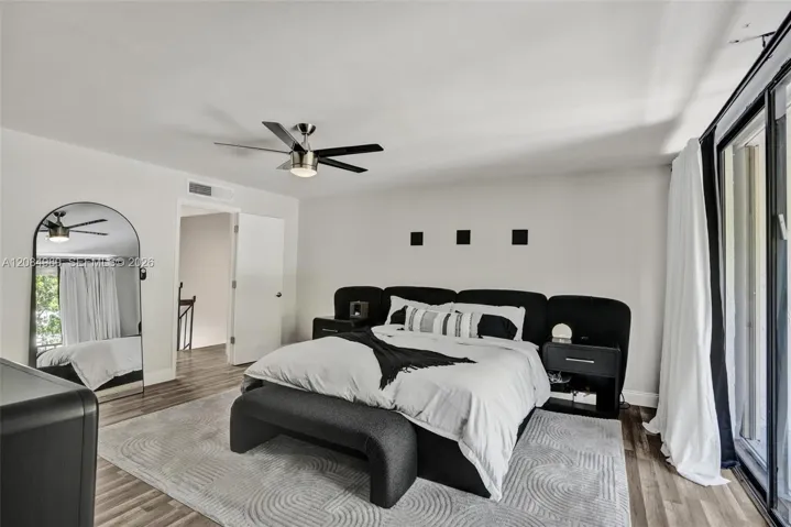Interior space featuring wood-finish flooring, a contemporary ceiling fan, and sliding glass doors