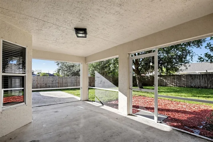 Screened-in patio with concrete flooring, stucco exterior walls, flush-mount lighting, and direct access to a fenced backyard