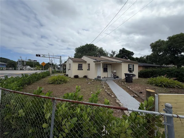 Single-story residence with a stucco exterior, covered front porch, and concrete walkway