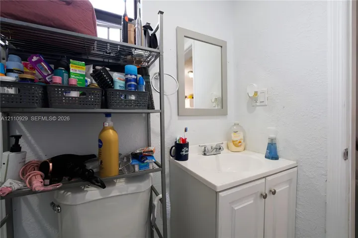 White vanity cabinet with an integrated basin, dual-handle chrome faucet, and framed wall mirror