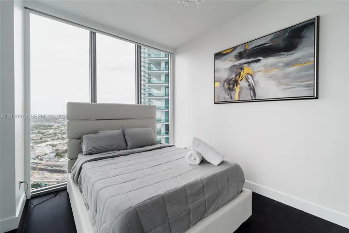 Floor-to-ceiling windows, dark wood-finish flooring, and recessed ceiling lighting