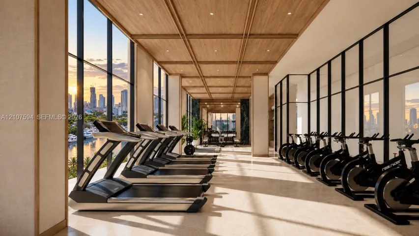 Fitness center featuring floor-to-ceiling windows, wood-paneled coffered ceilings, recessed lighting, and stone-finish flooring