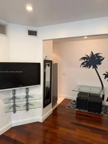 Wood-finish flooring, wall-mounted glass shelving, and recessed lighting