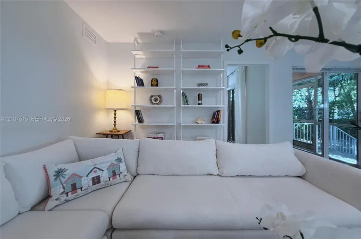 Built-in white floor-to-ceiling shelving and glass sliding doors leading to the screened-in porch