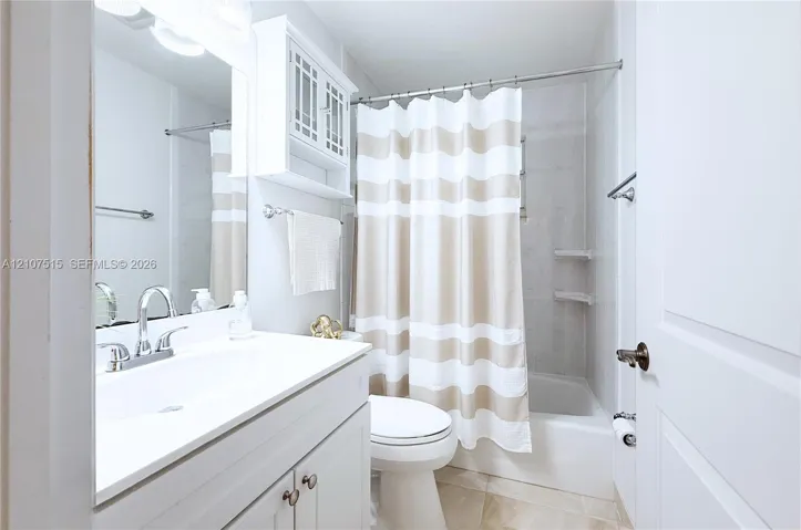Second bathroom featuring a white vanity with an integrated sink, brushed-nickel faucet, wall-mounted cabinet; shower-tub combination.
