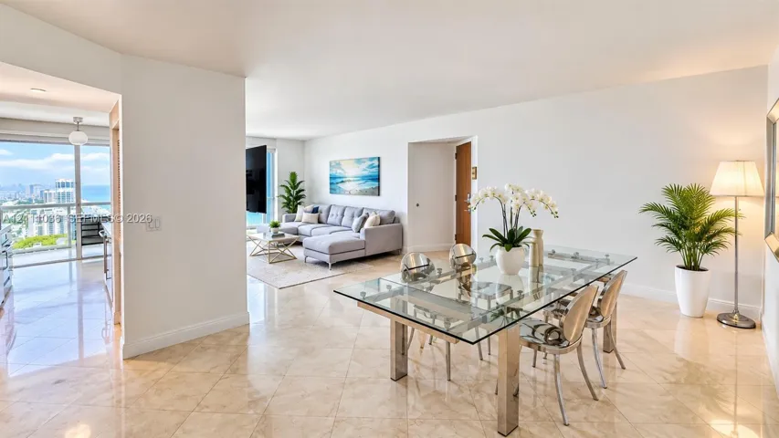 Open-concept living space featuring polished tile flooring, floor-to-ceiling glass sliding doors, and a private balcony