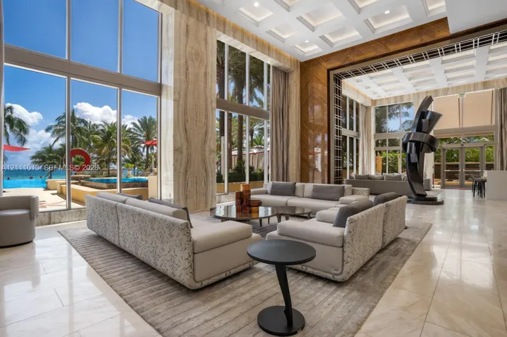 Double-height floor-to-ceiling windows, coffered ceilings, stone wall cladding, polished tile flooring, and integrated recessed lighting