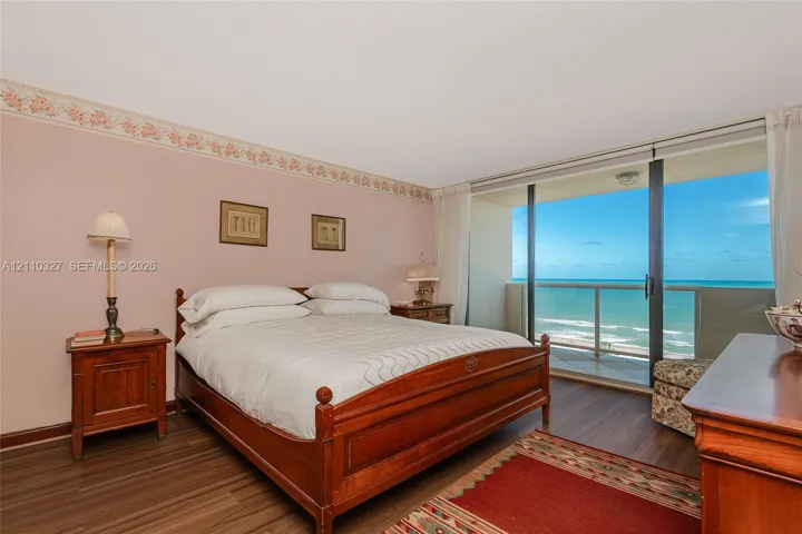 Wood-finish flooring, sliding glass balcony doors, and prominent ocean exposure