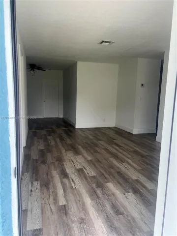 Interior space featuring wood-finish flooring, white walls, and a ceiling-mounted light fixture