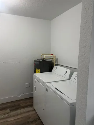 Utility area featuring wood-finish flooring and an upright water heater