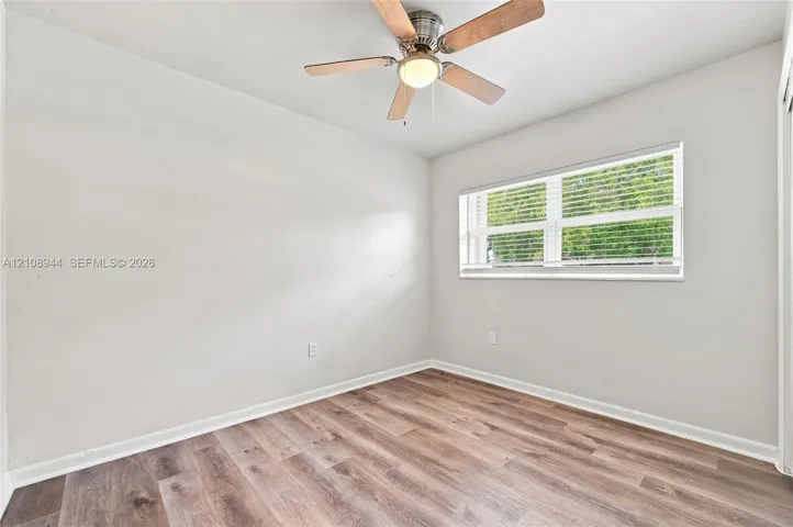 Wood-finish flooring, neutral wall tones, multi-pane window with blinds, and ceiling fan with integrated​​‌​​​​‌​​‌‌​‌‌​​​‌‌​‌​‌​‌​​​‌​​ lighting