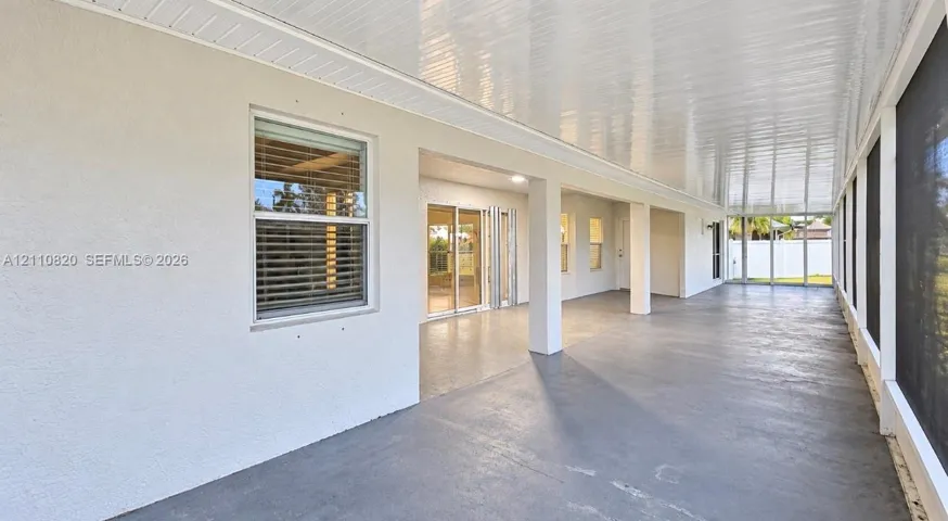Covered, screened-in lanai featuring a solid concrete floor, recessed ceiling lighting, and exterior access via sliding glass doors