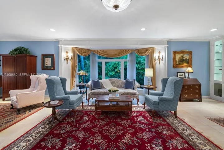 Large bay window featuring recessed lighting, custom wall-mounted sconces, light-toned tile flooring, and built-in glass-front cabinetry