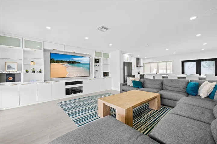 Custom floor-to-ceiling built-in cabinetry, recessed lighting, and large-format tile flooring