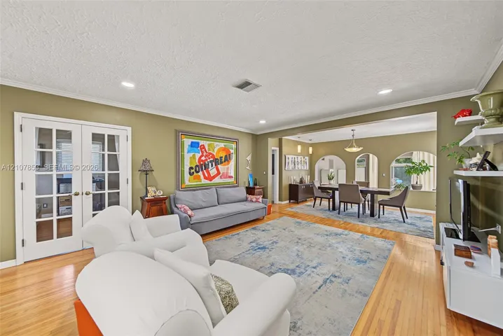 Living Room - Entering through the front door with views to the Dining Area and beyond. French doors lead to the Office/Den