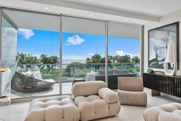 Floor-to-ceiling sliding glass walls, recessed ceiling lighting, and a private balcony with glass railingcorner unit overlooking direct ocean views