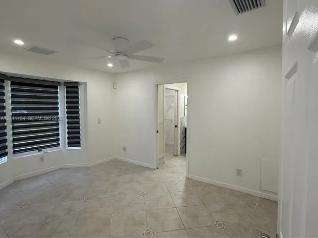 Room featuring bay windows, tile flooring with decorative inlay, recessed ceiling lighting, and a modern ceiling fan