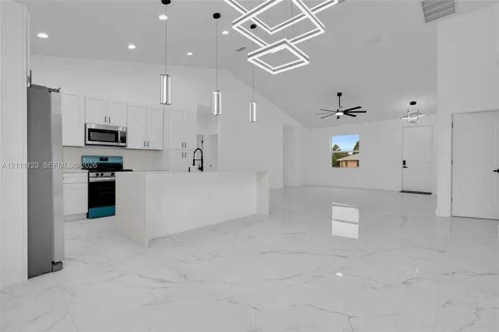 Kitchen with off-white cabinetry, stainless steel appliances, and pendant lighting over the island.