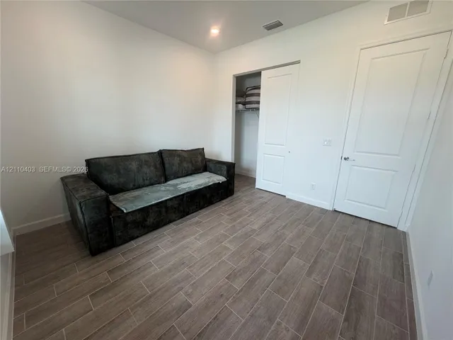 Neutral interior featuring wood-finish tile flooring, recessed lighting, and a closet with a sliding door