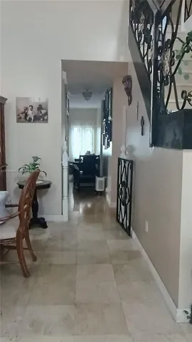 Entry featuring stone-finish flooring and a staircase with decorative wrought-iron railings