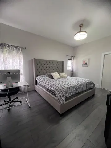 Wood-finish plank flooring, neutral wall tones, and overhead semi-flush mount lighting