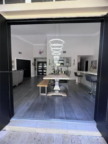 Interior space featuring wood-finish flooring, vaulted ceilings, and a multi-tiered circular pendant light fixture