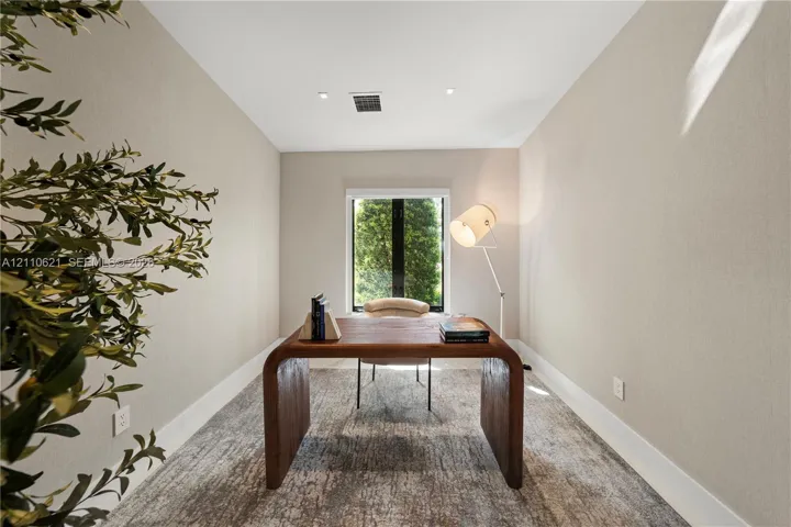 Neutral-toned wall finishes, recessed ceiling lighting, and a single-pane window with a black frame