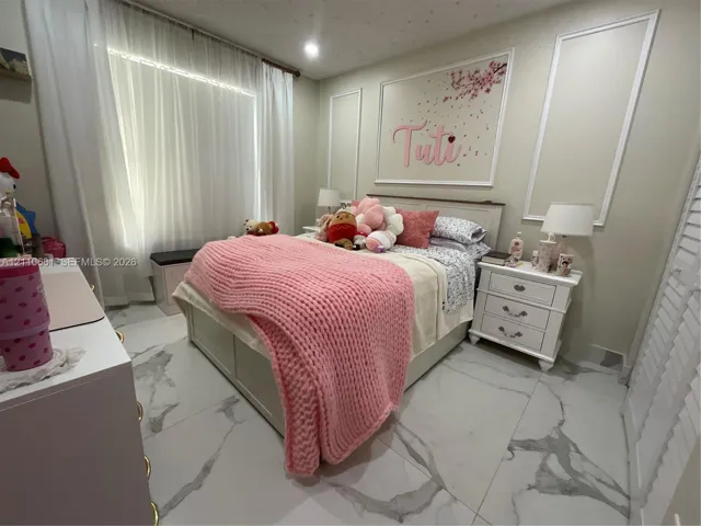 Large-format stone-finish floor tiling, wall molding detailing, and shutter-style closet doors