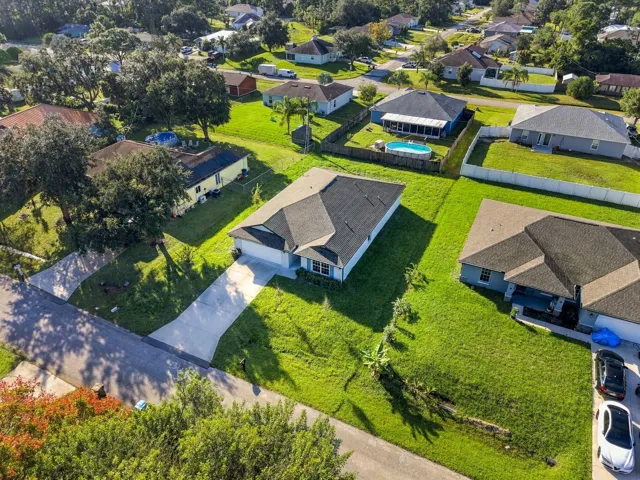 Aerial view showing the front of the home and neighboring properties.
