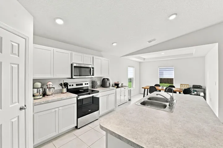 White shaker cabinetry, stainless steel appliances and a pantry.