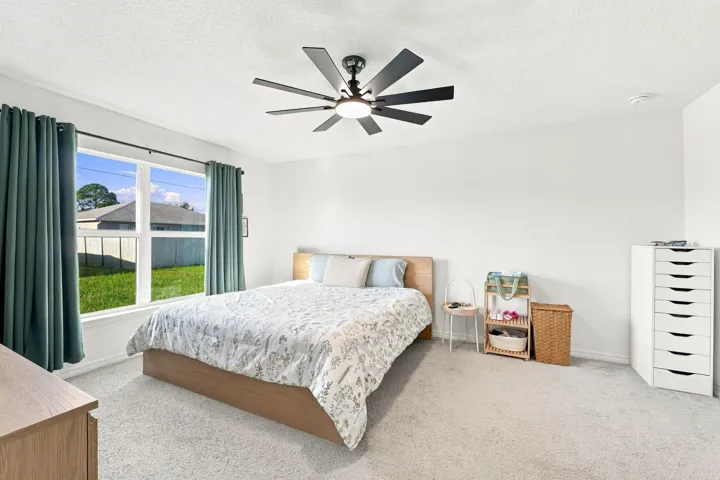 Bright primary bedroom with backyard views.