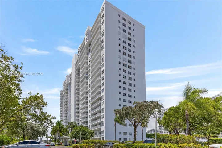 High-rise residential building featuring a concrete facade, tiered architectural structure, and multiple levels of private balconies