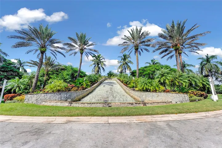 Stone-clad water feature surrounded by lush tropical landscaping and mature palm trees