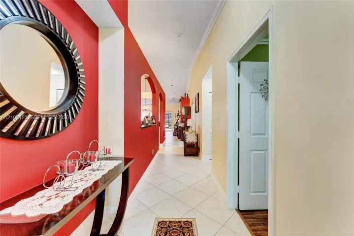 Entryway featuring light-colored tile flooring, accent wall, and arched wall cutouts