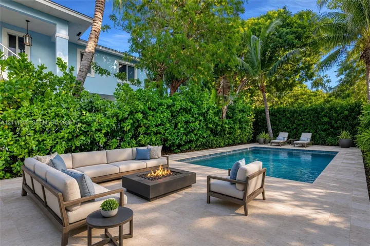 AI Generated Outdoor living space featuring a rectangular swimming pool, stone-paver decking, built-in fire feature, and privacy-hedged perimeter