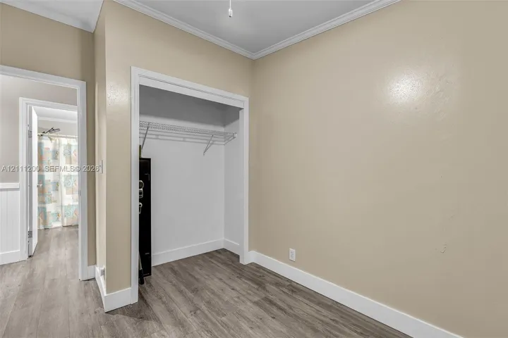 Neutral wall color, wood-finish flooring, and built-in closet shelving