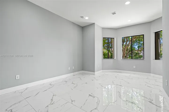 Polished tile flooring with marble-patterned veining, recessed lighting, and a bay window configuration