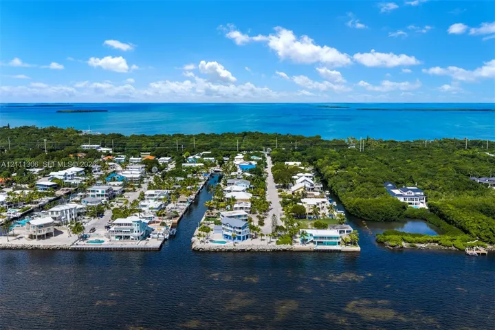 Aerial perspective of waterfront properties featuring direct canal access, seawalls, and proximity to the open ocean
