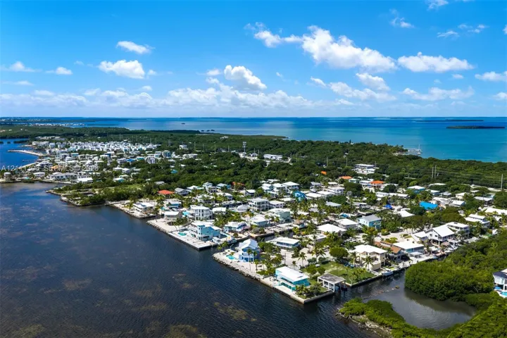 Aerial perspective featuring coastal positioning, deep-water access, mature tropical vegetation, and direct shoreline proximity