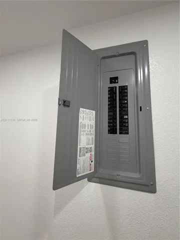 Flush-mounted electrical service panel featuring a metal enclosure, hinged door, and multiple circuit breakers
