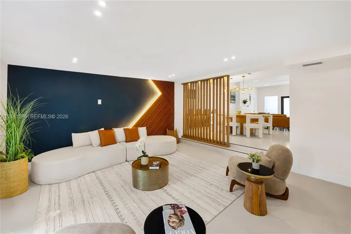 Living area featuring a floor-to-ceiling wooden slat partition, recessed lighting, and a dual-tone accent wall with integrated LED strip lighting