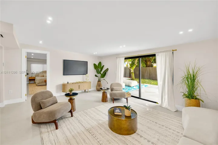 Neutral-toned interior featuring recessed lighting, polished light-colored flooring, and large sliding glass doors