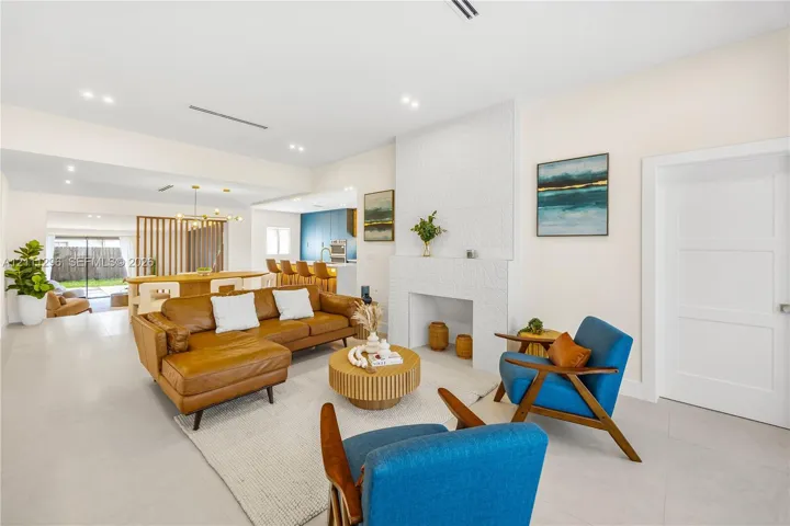 Living area featuring a floor-to-ceiling textured tile fireplace surround, recessed lighting, and neutral large-format tile flooring