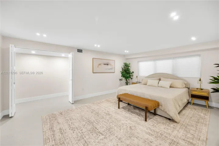 Spacious room featuring neutral wall tones, recessed lighting, tile flooring, and a large reach-in closet with bi-fold doors