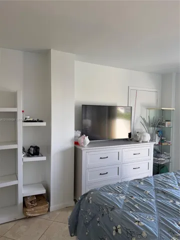 Built-in white shelving unit and large-format tile flooring